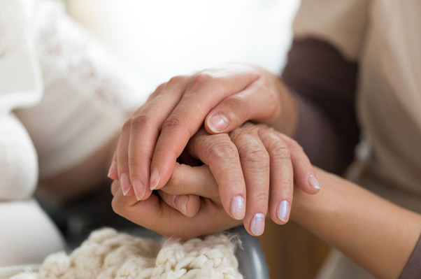 Image of a senior person engaging in activities with a caregiver, symbolizing support and care for individuals with Parkinson's Disease in an assisted living setting.